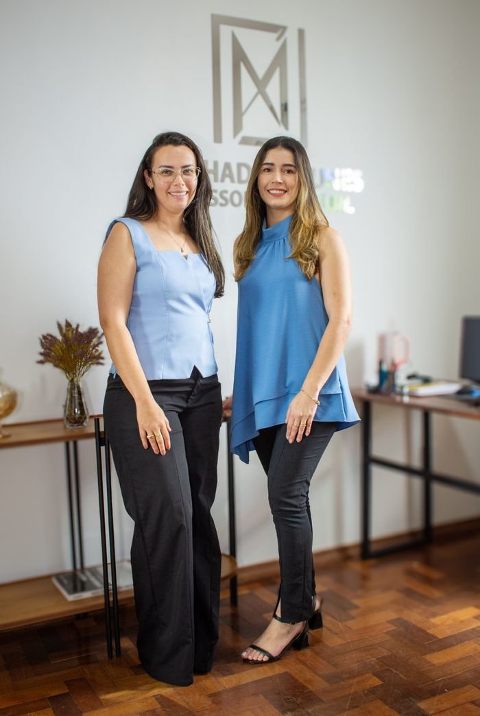 Services Two professional women pose confidently in a modern office in Tiros, Brazil.